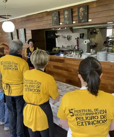 Grupo de personas atendiendo a una explicación en una cocina de restaurante