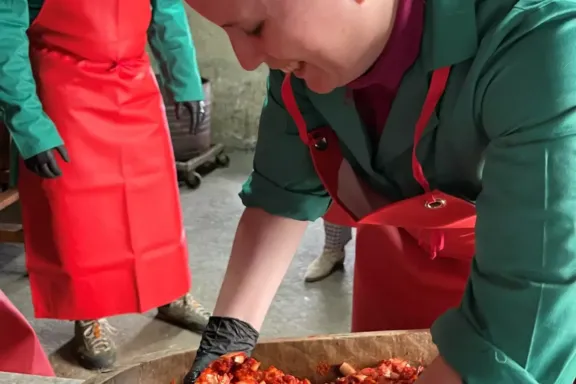 Mujer amasando una mezcla de carnes y condimentos