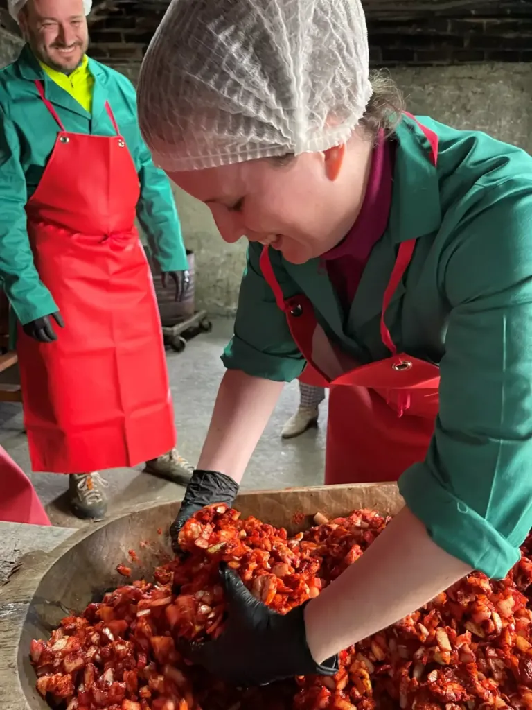 Mujer amasando una mezcla de carnes y condimentos