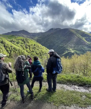 Personas observando un valle desde un camino