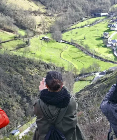 Personas sacando fotos a un pueblo desde una montaña