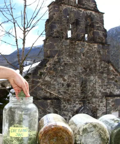 Varios tarros de cristal con especias delante de una capilla de piedra
