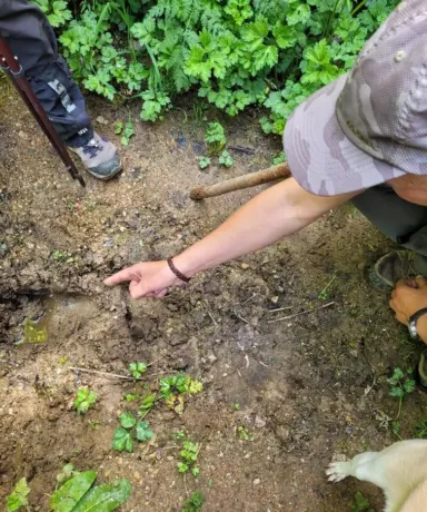 Hombre señalando con el dedo una huella en el suelo